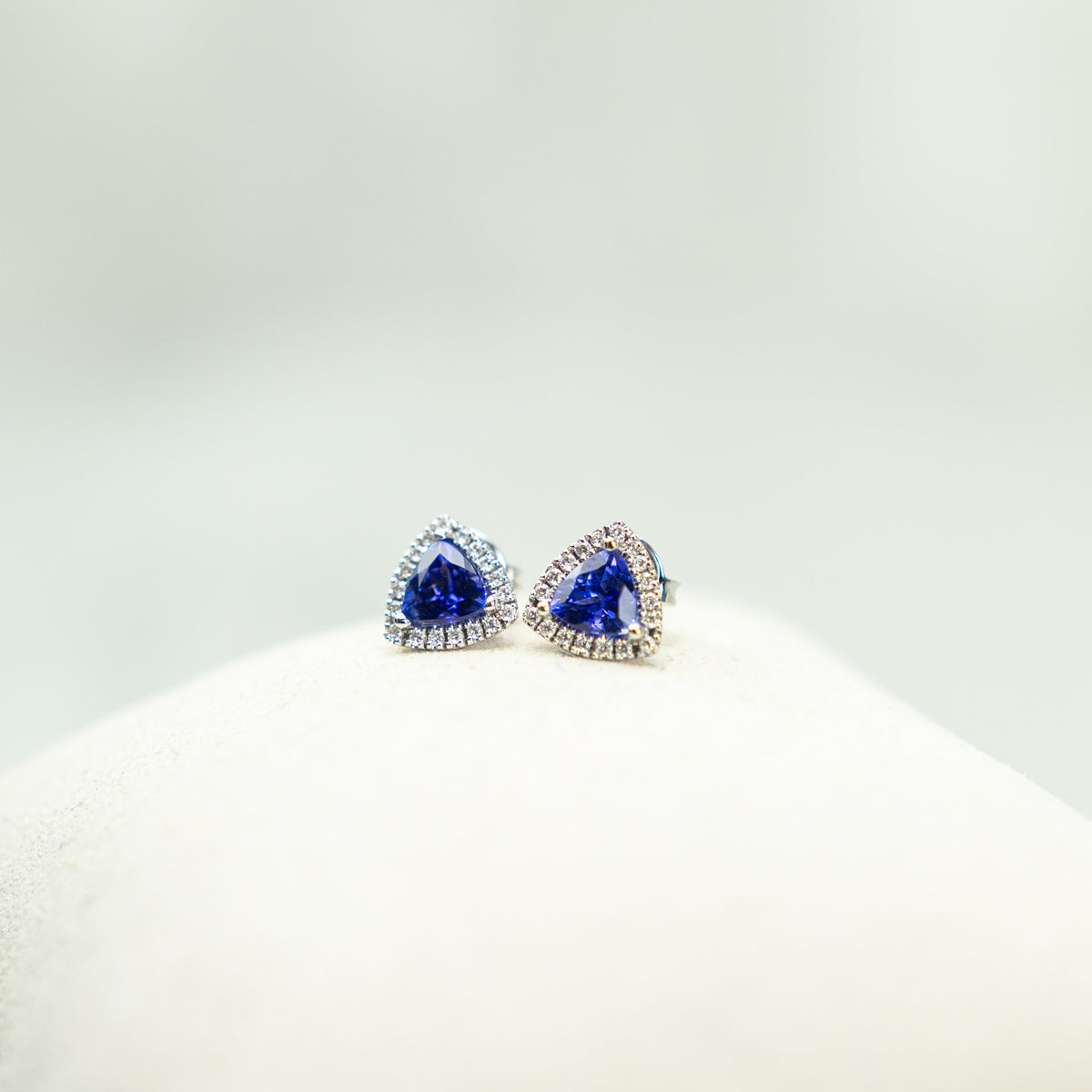 18ct White Gold Trilliant Cut Tanzanite And Diamond Halo Stud Earrings available at RR Jewellers Yarm