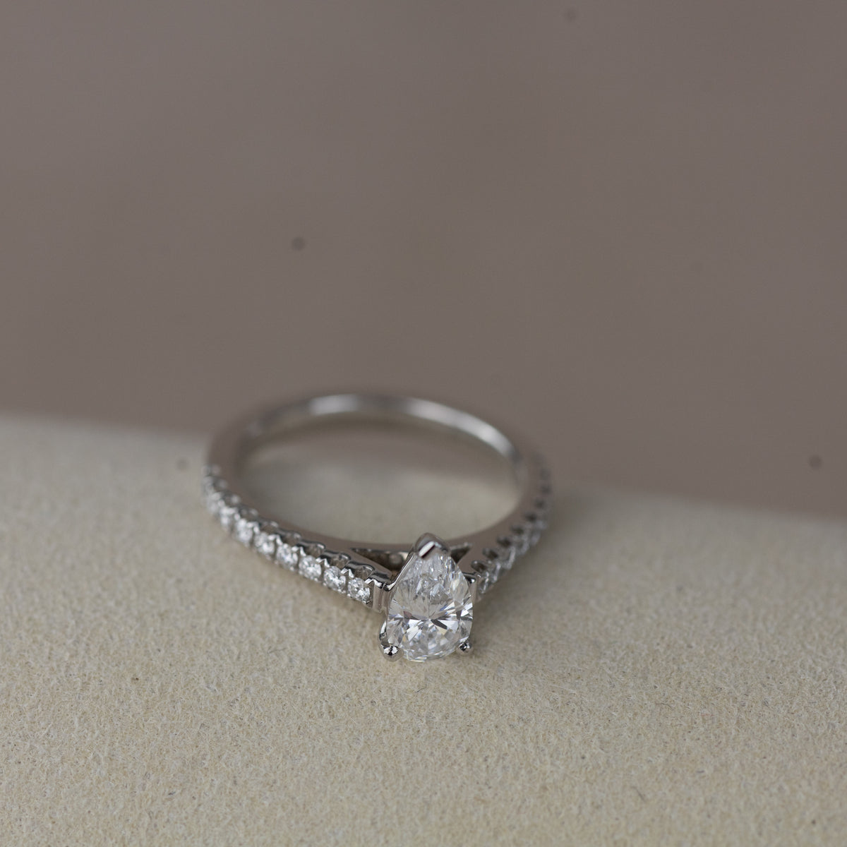 Platinum pear cut 0.70ct solitaire ring with diamond set shoulders