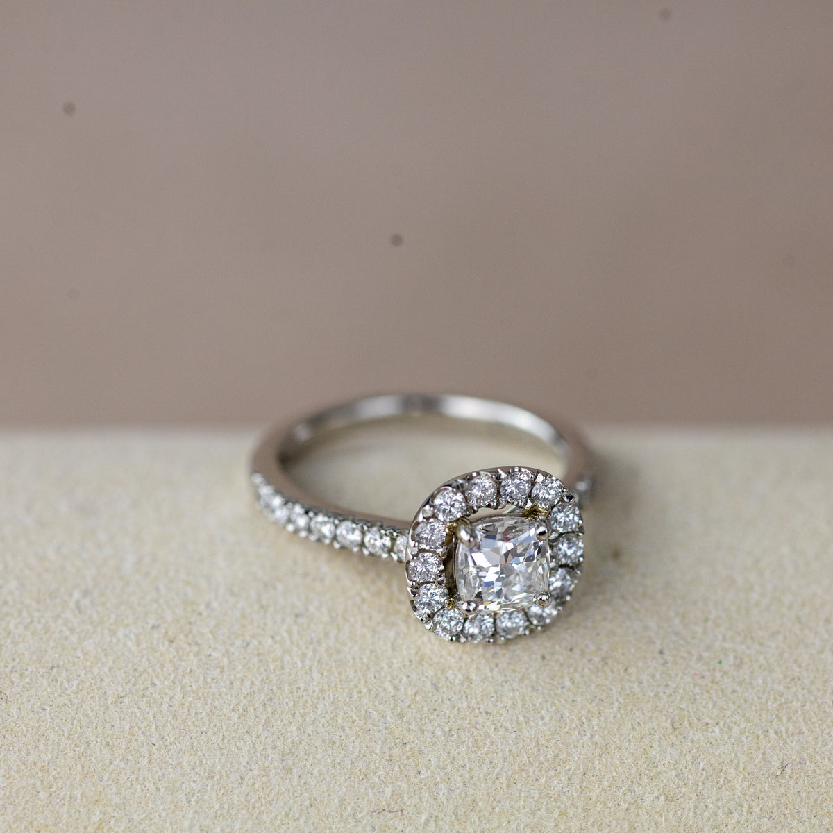 Platinum 0.70ct cushion cut diamond halo ring with diamond set shoulders