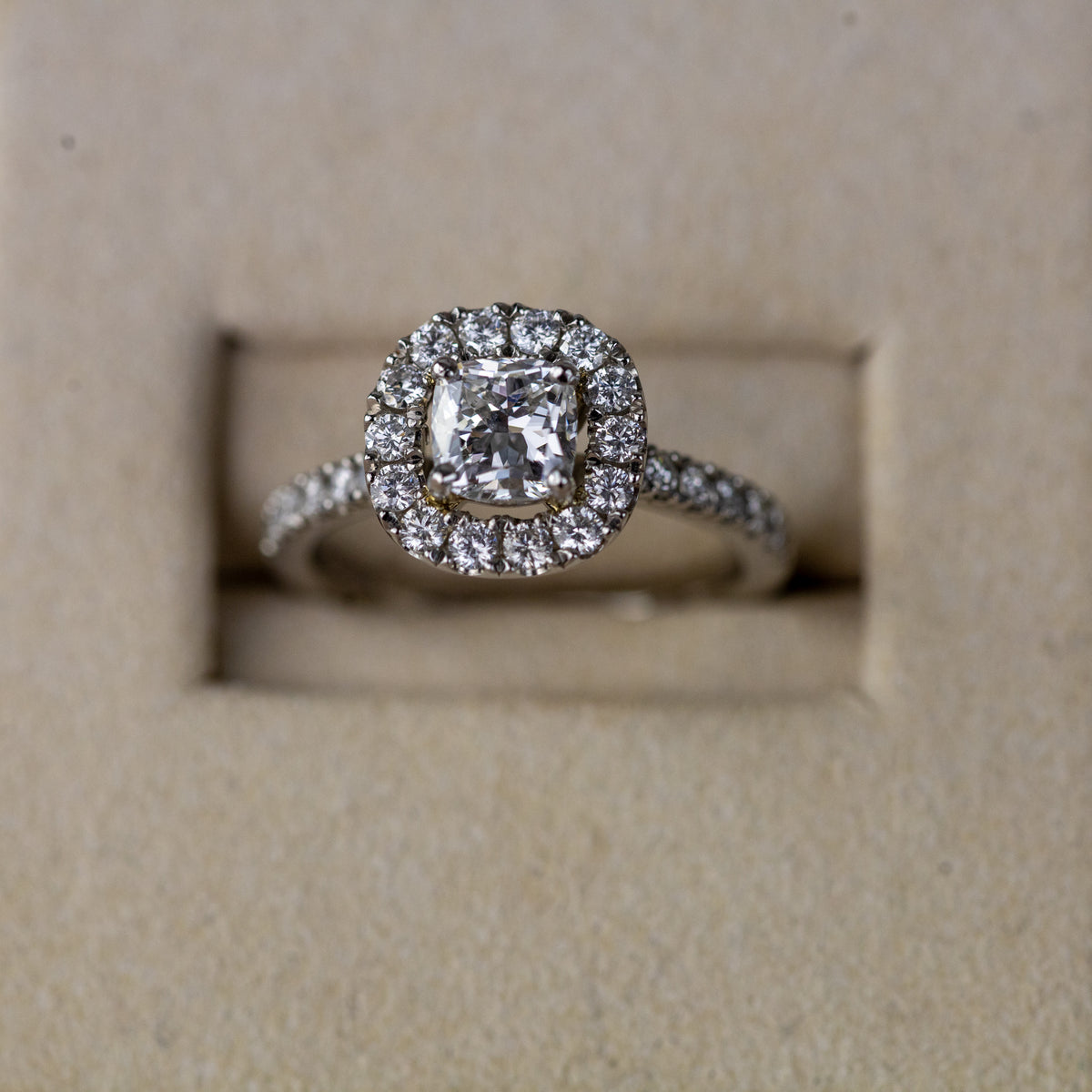 Platinum 0.70ct cushion cut diamond halo ring with diamond set shoulders