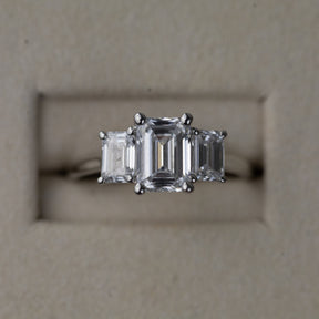 Platinum graduated 2.59ct emerald cut diamond trilogy ring
