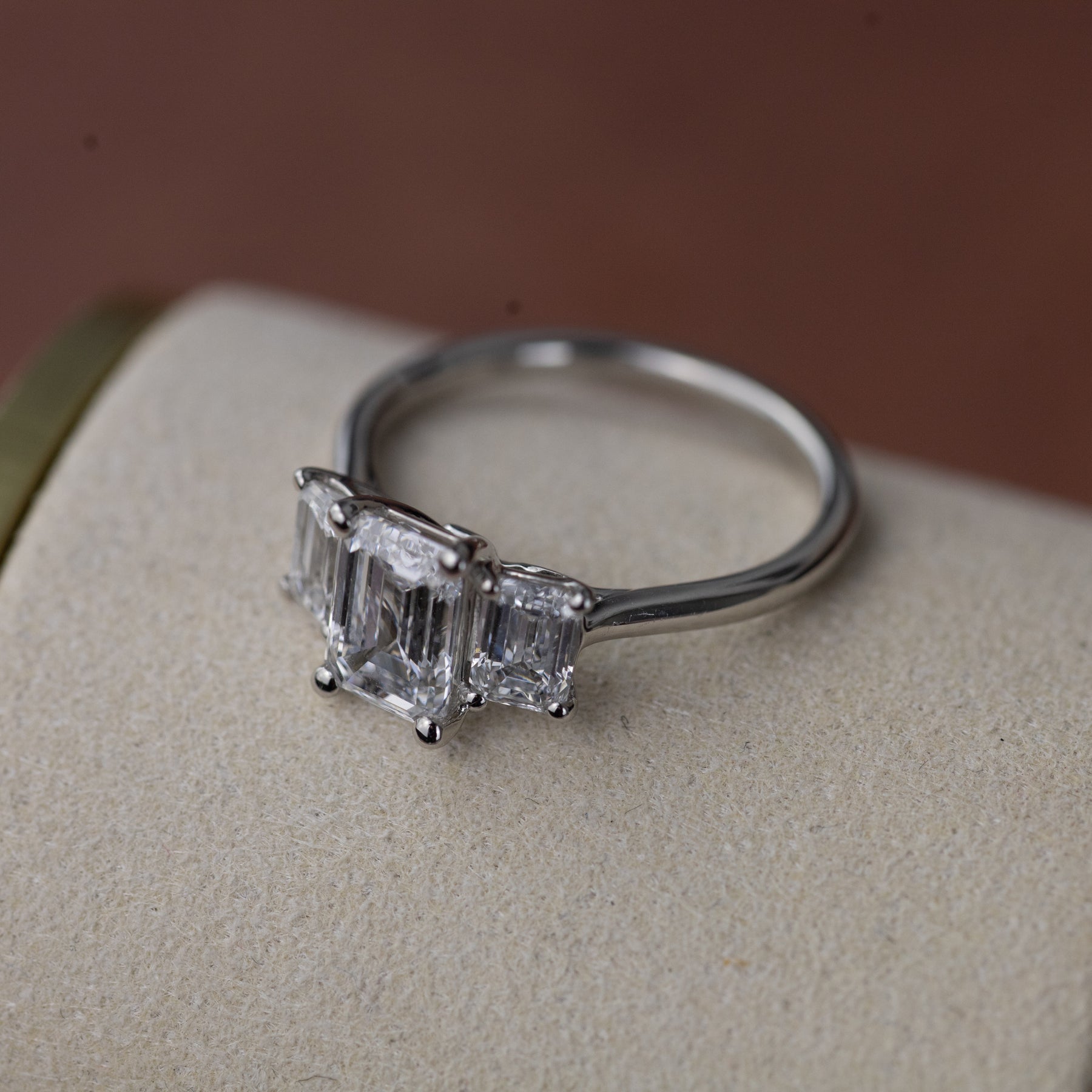 Platinum graduated 2.59ct emerald cut diamond trilogy ring