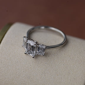 Platinum graduated 2.59ct emerald cut diamond trilogy ring