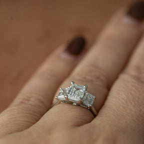 Platinum graduated 2.59ct emerald cut diamond trilogy ring
