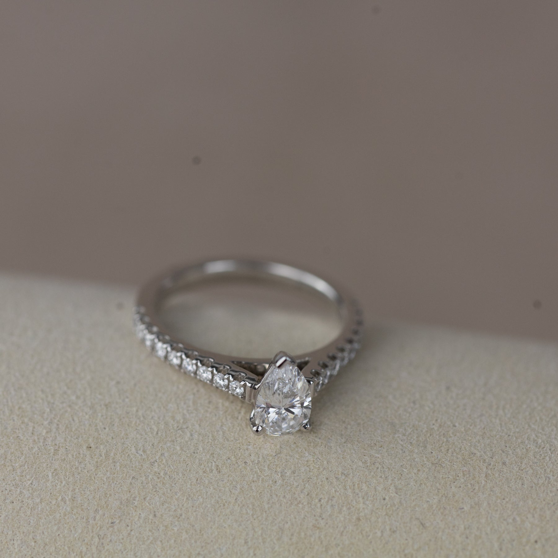 Platinum pear cut 0.70ct solitaire ring with diamond set shoulders