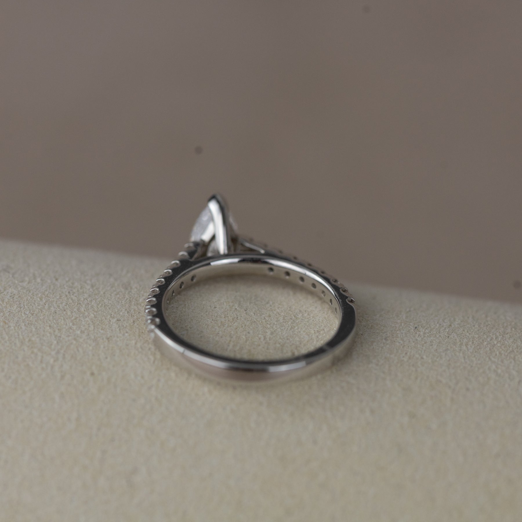 Platinum pear cut 0.70ct solitaire ring with diamond set shoulders