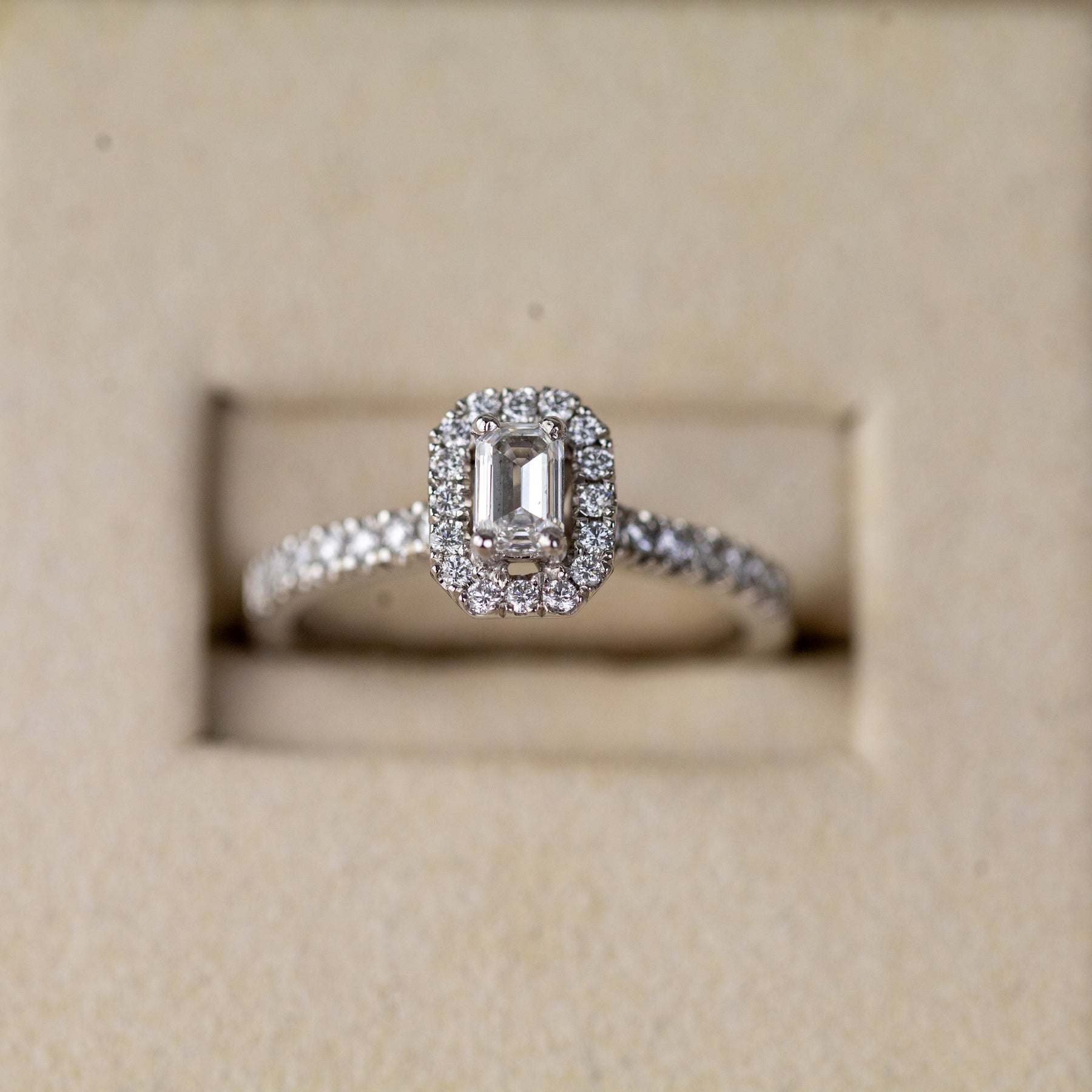 Platinum 0.33ct emerald cut lab diamond halo ring with diamond shoulders