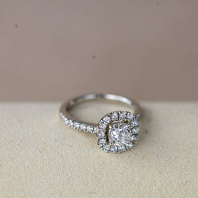 Platinum 0.70ct cushion cut diamond halo ring with diamond set shoulders