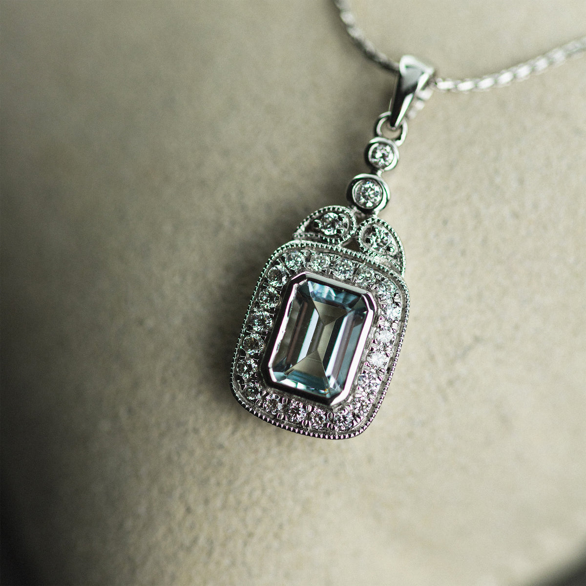 18ct White Gold Emerald Cut Aquamarine & Diamond Halo Pendant available at RR Jewellers Yarm