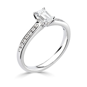 Emerald cut 4 claw diamond channel set ring